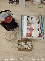 Group shot of entire lot showing punch bowl, tote with food containers, bin of disposable tableware and box of cups