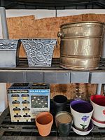 Assorted planters and boxed Westinghouse solar lights on shelving