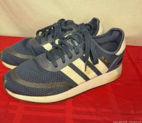 Side view of both sneakers showing mesh, suede overlays, stripes, and gold N-5923 text.