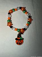 Front view showing multicoloured beads and enamel pumpkin charm