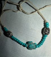 Full view of bracelet showing beads, metal accents, and cord ends