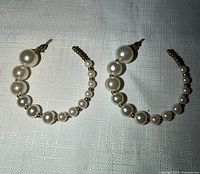 both hoop earrings front view on textured cloth