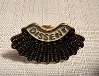 Front view of enamel pin showing full design and text