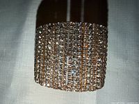 front view showing rows of clear crystals on goldtone cuff
