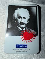 Front of rectangular pin with Einstein portrait, red heart and logo