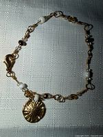 Full view of bracelet laid flat showing charm, beads and lobster clasp