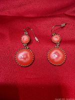 front view of both earrings showing orange stones and gold bezels