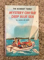 Front cover with title, author, sailing illustration