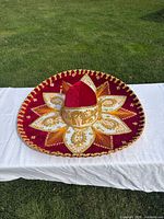 Front top view of red velvet sombrero with gold embroidery and cord edge