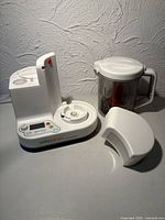 Front view of base unit, jar, red plunger, white cover