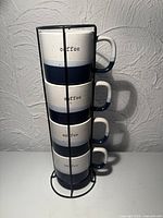 four mugs stacked in metal rack