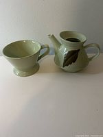 Teapot and cup side by side, showing overall shape and color