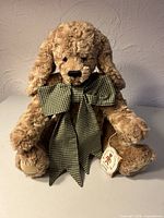Front view of tan plush dog with gingham bow