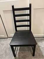 Front view of black ladder-back chair