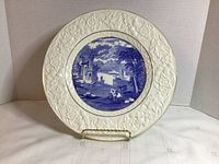 Full view of embossed white plate with blue scenic center