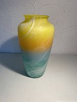 Front view showing yellow top, teal base, white swirls