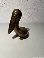 Front-left view of brass pelican figurine