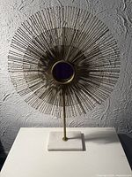 Front view of sunburst tabletop mirror showing full design and marble base
