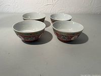 Four porcelain bowls arranged side by side showing interiors and exterior motif