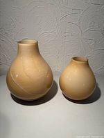 Front view of both peach-orange swirled vases