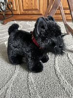 Full left side view of black Scotty dog plush with plaid scarf