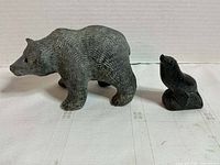 Gray soapstone bear and black seal figurines side by side