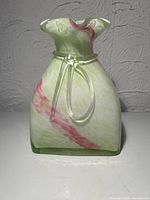 Front view showing swirled colors, ruffled rim, clear glass tie, square base