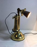 Front view of brass telephone-style lamp lit