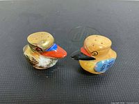 Front angled view of both bird shakers showing color and holes