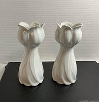 Front view of two matching white lotus vases