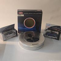 All three sealed die-cast cars: Corgi James Bond round tin in display box, Welly BMW 645Ci silver, Welly Ford convertible blue