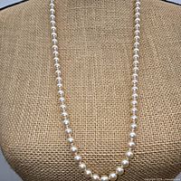 close view of simulated pearl strand on display bust