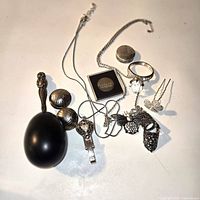 Overview of assorted silver and costume jewelry pieces laid out on surface