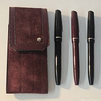 Three Osmiroid fountain pens and suede pouch displayed on flat surface