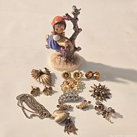 Group shot of figurine and all jewelry pieces laid out