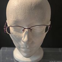 Front view of purple and silver semi-rimless eyeglass frames on display head