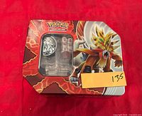 Closed Pokemon TCG tin with dice visible through window