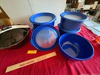 Overall view of five blue bowls with lids and black soup tureen
