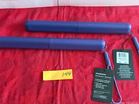 Two closed purple Starbucks recycled plastic travel cases with tags