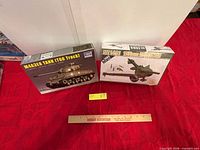 Both sealed model kit boxes beside ruler for scale