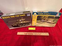 Both boxed model kits with ruler for scale