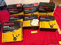 Seven RoadKing Bluetooth headset boxes on red surface