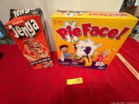 Jenga and Pie Face game boxes front view on table