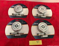 All four sealed Viacell LED pucklight packs displayed on red background with lot number card