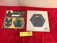 Two Halo Infinite patch packages side by side on red cloth