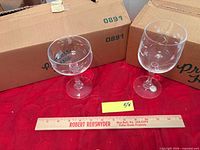 Sherbet coupe and wine goblet side by side with ruler for scale