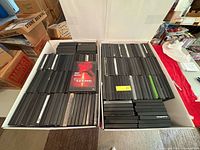 Two large boxes filled with stacked slim DVD cases