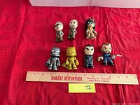 Group of eight Funko Mystery Minis figures laid out with ruler for scale