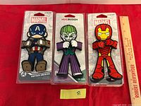 Front view of three packaged cellphone holders with ruler for scale