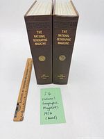 Two bound 1956 National Geographic volumes standing upright with ruler for scale